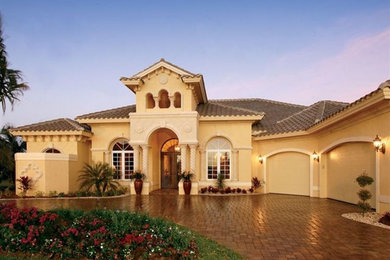 Inspiration for a large mediterranean beige two-story stucco exterior home remodel in Tampa