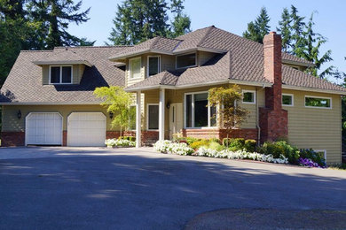 Large traditional two-storey yellow house exterior in Seattle with a hip roof and a shingle roof.