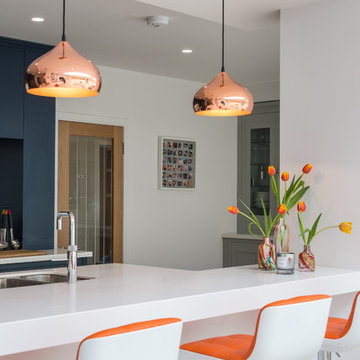 Kitchen in navy, white and grey with orange and copper accents