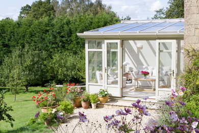 Bespoke white timber lean-to conservatory extension on a quintessential country