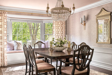 Inspiration for a mid-sized traditional separate dining room in St Louis with pink walls, dark hardwood floors, wallpaper and brown floor.
