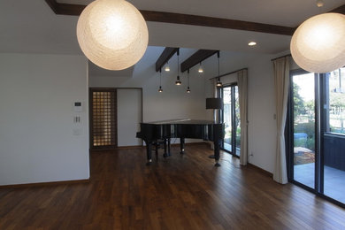 Стильный дизайн: открытая гостиная комната в восточном стиле с белыми стенами, темным паркетным полом, отдельно стоящим телевизором и коричневым полом без камина - последний тренд