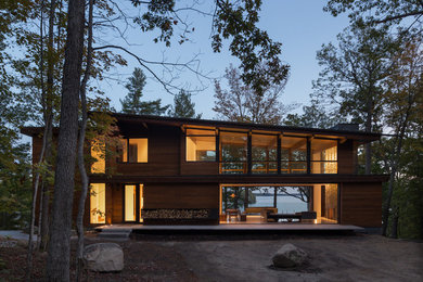 Inspiration for a contemporary two-storey brown house exterior in Other with wood siding.