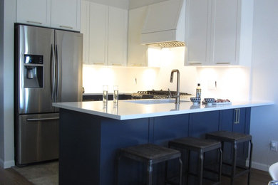 Inspiration for a mid-sized transitional u-shaped marble floor and gray floor eat-in kitchen remodel in Vancouver with a double-bowl sink, shaker cabinets, blue cabinets, quartzite countertops, white backsplash, stone slab backsplash, stainless steel appliances and white countertops
