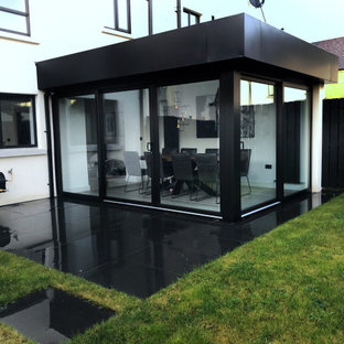 Mittelgroße Moderne Wohnküche mit weißer Wandfarbe, Laminat, Kaminofen und grauem Boden in Belfast