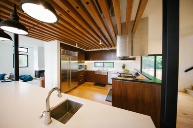 Kitchen - contemporary light wood floor and brown floor kitchen idea in San Diego with a farmhouse sink, flat-panel cabinets, medium tone wood cabinets, quartz countertops, white backsplash, subway tile backsplash, stainless steel appliances, an island and white countertops