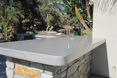 Large island style backyard stone patio kitchen photo in San Diego with no cover