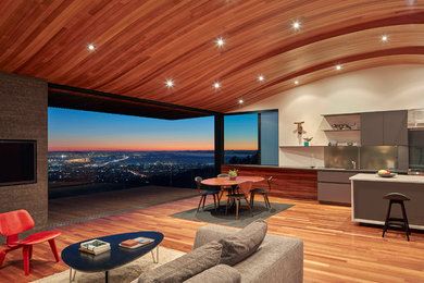 Example of a large trendy single-wall light wood floor eat-in kitchen design in Orange County with an undermount sink, flat-panel cabinets, gray cabinets, beige backsplash, stainless steel appliances and an island