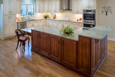 Kitchen - large traditional u-shaped medium tone wood floor and brown floor kitchen idea in Raleigh with an undermount sink, raised-panel cabinets, stainless steel appliances, an island, white cabinets, quartz countertops, white backsplash and wood backsplash
