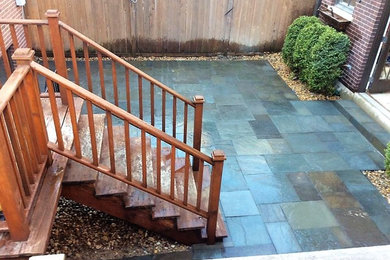 Photo of a small contemporary back patio in Chicago with natural stone paving.