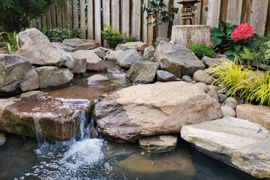Inspiration for a small backyard stone patio fountain remodel in Portland