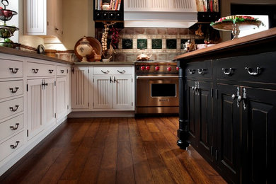Eat-in kitchen - large country l-shaped medium tone wood floor eat-in kitchen idea in Other with an undermount sink, glass-front cabinets, black cabinets, wood countertops, metallic backsplash, ceramic backsplash, stainless steel appliances and an island