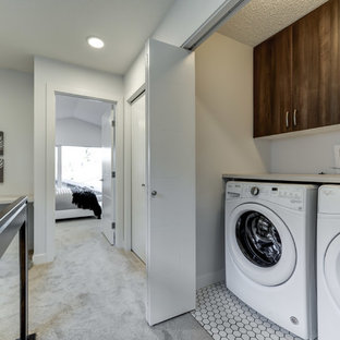 Inspiration for a small contemporary single-wall laundry cupboard in Edmonton with flat-panel cabinets, brown cabinets, laminate countertops, white walls, ceramic flooring, a side by side washer and dryer, white floors and white worktops.