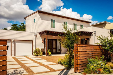 Example of a mid-sized trendy white two-story wood townhouse exterior design in Other with a shed roof and a metal roof
