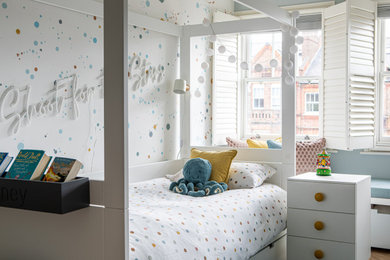 Photo of a medium sized contemporary teen’s room for girls in London with blue walls, light hardwood flooring, grey floors, wallpapered walls and feature lighting.