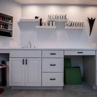 Photo of a large modern craft room in San Francisco with blue walls, a built-in desk, slate flooring, no fireplace and grey floors.