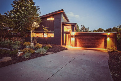 This is an example of a midcentury two-storey brown house exterior in Salt Lake City with wood siding and a butterfly roof.
