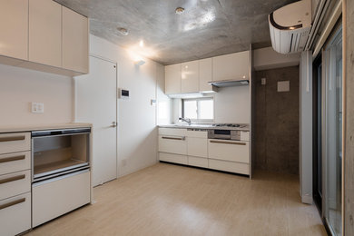 Photo of a mid-sized modern single-wall open plan kitchen in Tokyo with a single-bowl sink, flat-panel cabinets, white cabinets, stainless steel benchtops, white splashback, glass sheet splashback, stainless steel appliances, vinyl floors, no island, pink floor and grey benchtop.