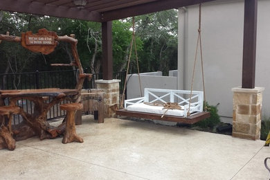 Inspiration for a mid-sized timeless backyard concrete patio kitchen remodel in Austin with a pergola