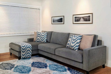 Photo of a mid-sized contemporary family room in Other with white walls, medium hardwood floors and brown floor.