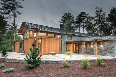 Large modern gray one-story mixed siding gable roof idea in Other
