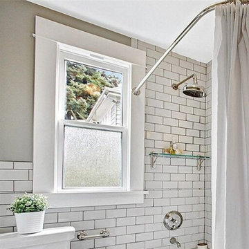 White subway tile, period appropriate fixtures and glass shower shelf