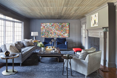 Living room - large transitional enclosed dark wood floor living room idea in New York with gray walls, a two-sided fireplace and a stone fireplace