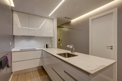 Design ideas for a mid-sized contemporary kitchen in Barcelona with flat-panel cabinets and a peninsula.