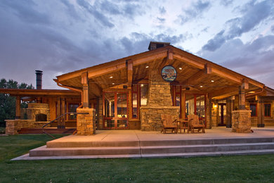 Inspiration for a rustic backyard concrete patio remodel in Other with a fire pit and a roof extension
