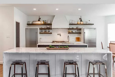 Example of a huge transitional single-wall dark wood floor and brown floor kitchen pantry design in Little Rock with a farmhouse sink, shaker cabinets, quartz countertops, white backsplash, ceramic backsplash, stainless steel appliances, two islands and white countertops