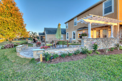 Inspiration for a large transitional backyard stone patio remodel in Orlando with a fire pit and a pergola