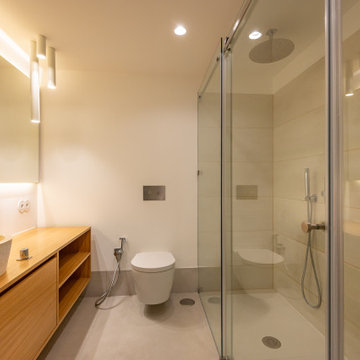 Bathroom Vanity with Glass Shower and Wood Cabinetry in Lisbon