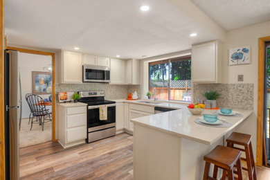 Enclosed kitchen - small transitional u-shaped vinyl floor and multicolored floor enclosed kitchen idea in Seattle with a double-bowl sink, recessed-panel cabinets, white cabinets, quartz countertops, multicolored backsplash, glass tile backsplash, stainless steel appliances, no island and white countertops