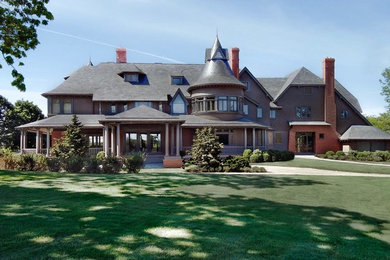 Huge elegant brown three-story mixed siding house exterior photo in New York with a clipped gable roof and a shingle roof