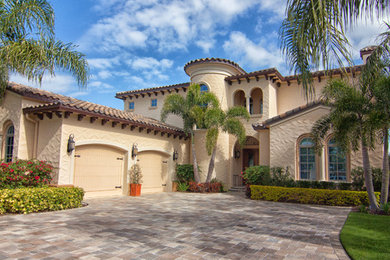 Inspiration for a mid-sized mediterranean two-storey adobe beige exterior in Orlando with a clipped gable roof.