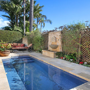 オレンジカウンティの小さい長方形地中海スタイルのおしゃれな裏庭プール (天然石敷き) の写真