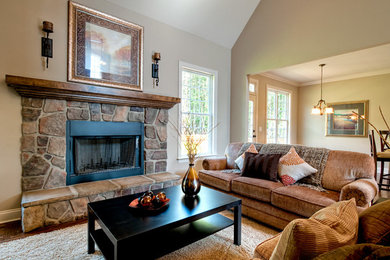 Family room - traditional enclosed dark wood floor family room idea in Other with beige walls, a standard fireplace, a stone fireplace and no tv