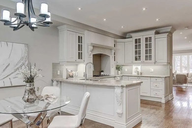 Eat-in kitchen - mid-sized traditional l-shaped porcelain tile and white floor eat-in kitchen idea in Toronto with an undermount sink, shaker cabinets, white cabinets, quartzite countertops, white backsplash, cement tile backsplash, stainless steel appliances, an island and white countertops