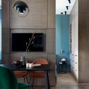 Идея дизайна: маленькая гостиная-столовая в современном стиле с синими стенами, паркетным полом среднего тона и коричневым полом