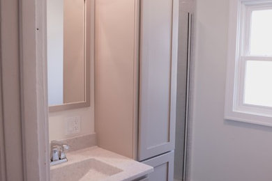 Inspiration for a small timeless master gray tile and subway tile vinyl floor and gray floor alcove shower remodel in Other with flat-panel cabinets, gray cabinets, a two-piece toilet, gray walls, an integrated sink, onyx countertops, a hinged shower door and gray countertops
