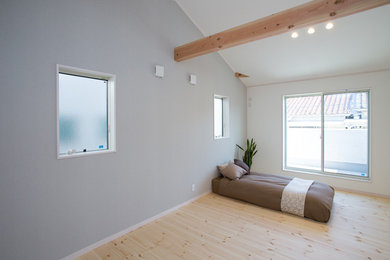 Modelo de dormitorio principal nórdico sin chimenea con paredes grises y suelo de madera clara