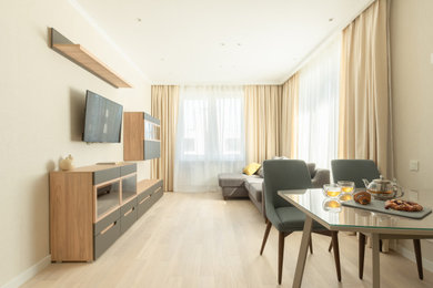 Идея дизайна: объединенная гостиная комната среднего размера, в белых тонах с отделкой деревом в современном стиле с бежевыми стенами, полом из ламината, телевизором на стене, зоной отдыха, бежевым полом и обоями на стенах