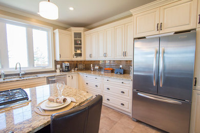 Inspiration for a large transitional l-shaped eat-in kitchen remodel in Other with an undermount sink, raised-panel cabinets, white cabinets, granite countertops, stainless steel appliances and an island