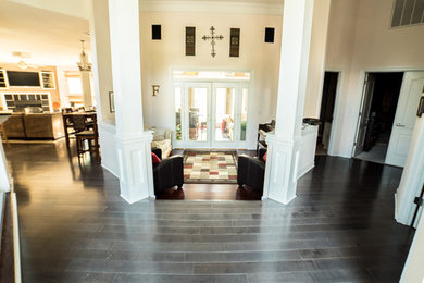 Entryway - large traditional dark wood floor entryway idea in Other with beige walls and a white front door
