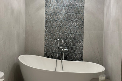 Inspiration for a small modern gray tile and porcelain tile gray floor freestanding bathtub remodel in Orlando with white cabinets, gray walls and a freestanding vanity