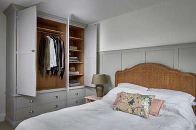 This is an example of a medium sized classic gender neutral standard wardrobe in West Midlands with shaker cabinets, grey cabinets and carpet.