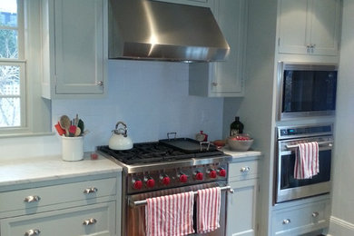 Large elegant l-shaped dark wood floor enclosed kitchen photo in New York with an undermount sink, recessed-panel cabinets, gray cabinets, marble countertops, stainless steel appliances and an island