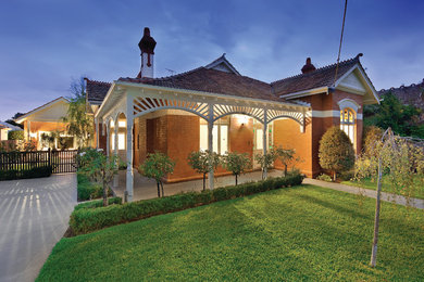 This is an example of a traditional front yard driveway in Melbourne with natural stone pavers.