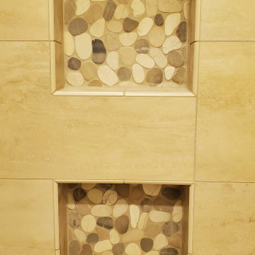Striking 12 x 24 tiles installed on shower walls with a decorative pebble floor