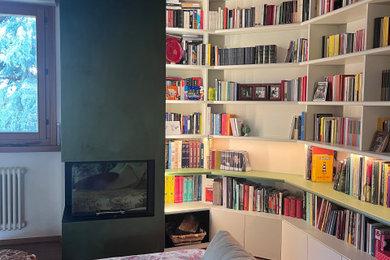 Ispirazione per un soggiorno design aperto con libreria, pareti verdi, parquet chiaro, camino ad angolo, cornice del camino in cemento e soffitto in legno
